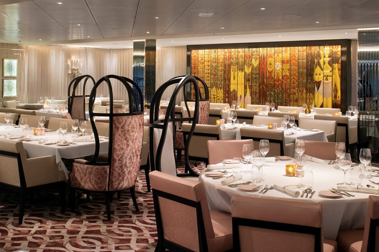 An upscale restaurant with white table linens and chandeliers